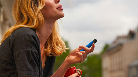 woman vaping and holding a red cup